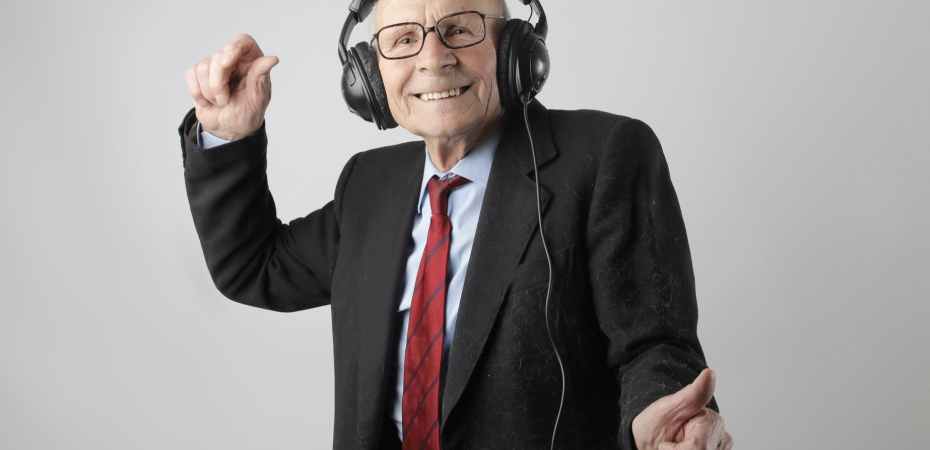 cheerful elderly man listening to music in headphones